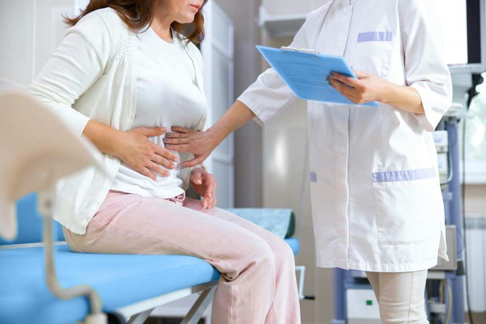 Femme ayant des douleurs abdominales et avec son docteur pour peut on vivre sans pancréas