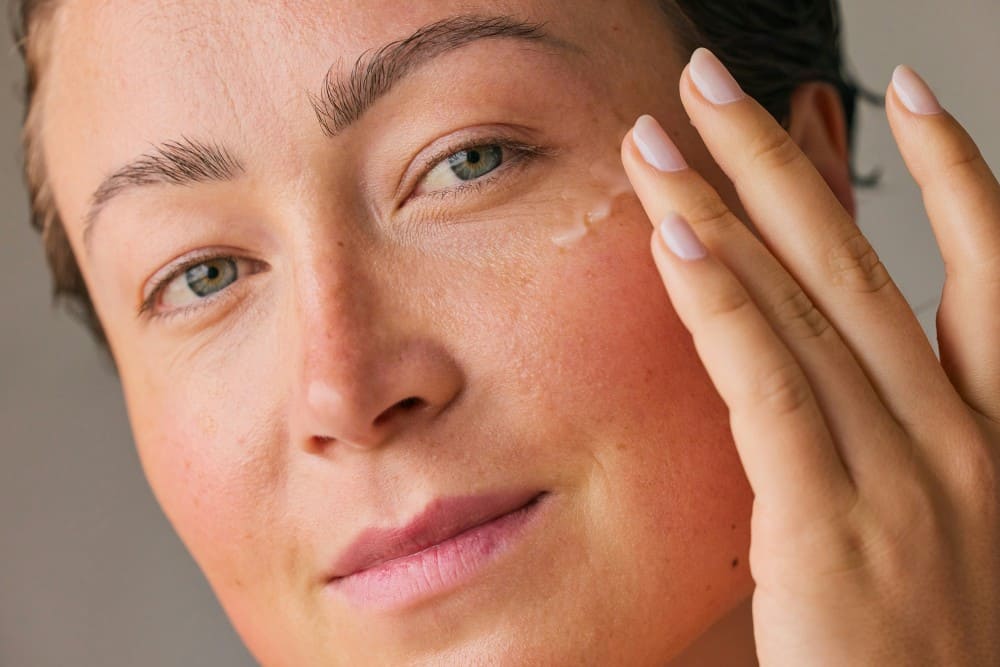 Photo d'une femme qui met un sérum, comment avoir une belle peau du visage