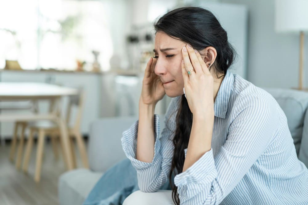Femme mettant ses mains au niveau des tempes, coup de chaleur