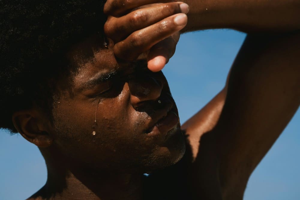 Homme noir qui transpire sous le soleil