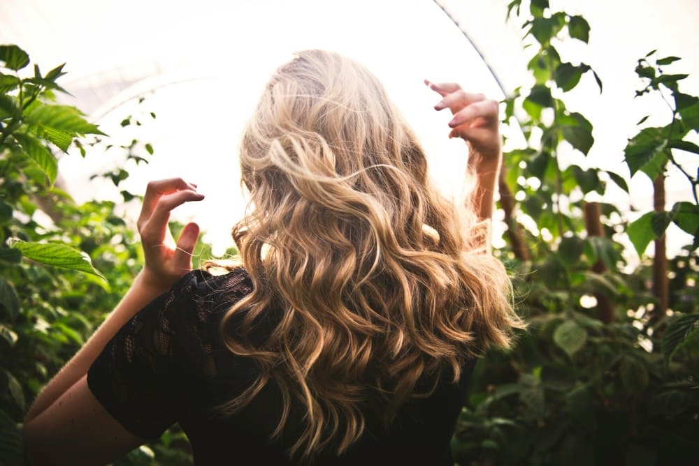 Femme aux longs cheveux bouclés, soin au beurre de karité